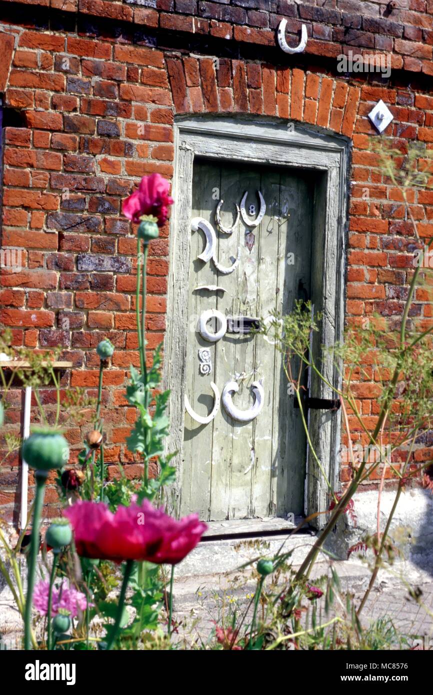 Horseshoe amulets on a door in Quainton, (Lower Road) covered in numerous amuletic horseshoes. Stock Photo