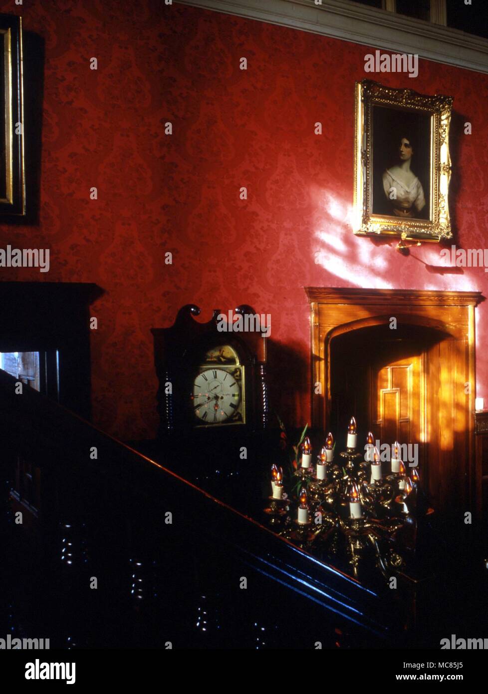 Interior of a great Gothic house, with chandelier, grandfather clock, and portraits. Stock Photo