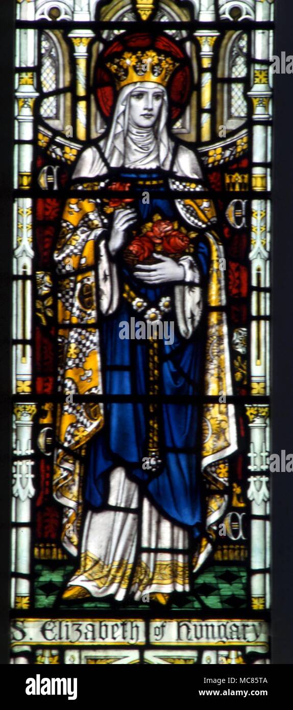 Christian St Catherine of Hungary, with her flowers. Stained glass window in the church of St Mary, Godstone, Surrey Stock Photo