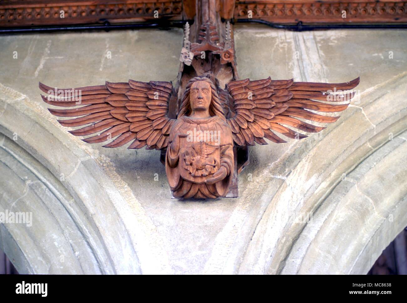 CHRISTIAN Wooden carving of an angel carrying the symbol of St Luke, the bull of Taurus. From the Church of St Mary, Woolpit Stock Photo