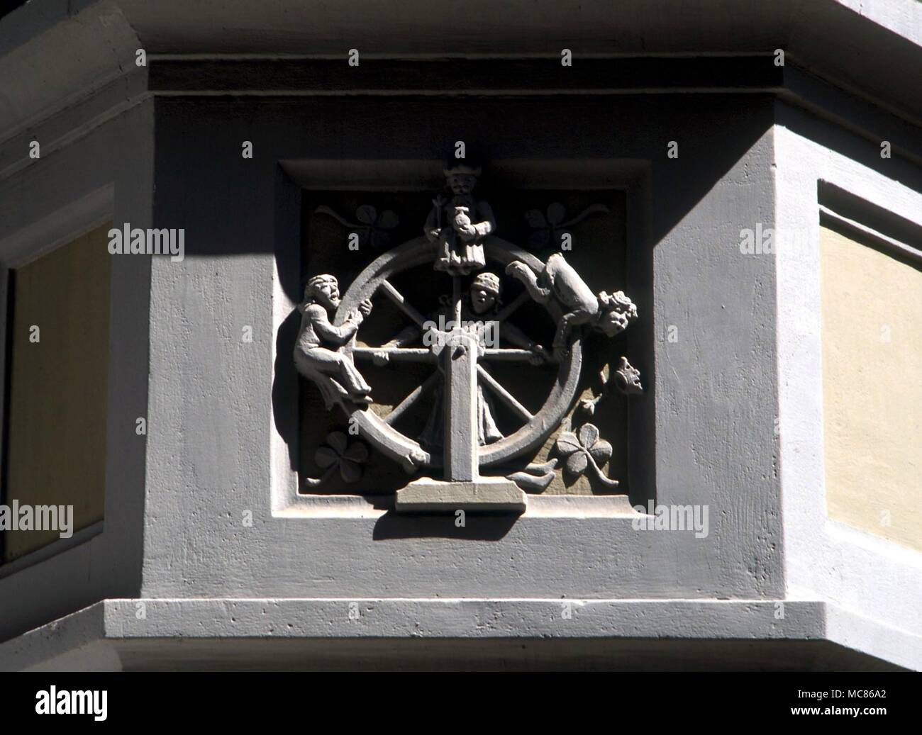 Wheel of Fortune, with one rising, one falling, and Fortune herself blindfold. Image on facade of a house in the Swiss town of Shaffhausen Stock Photo