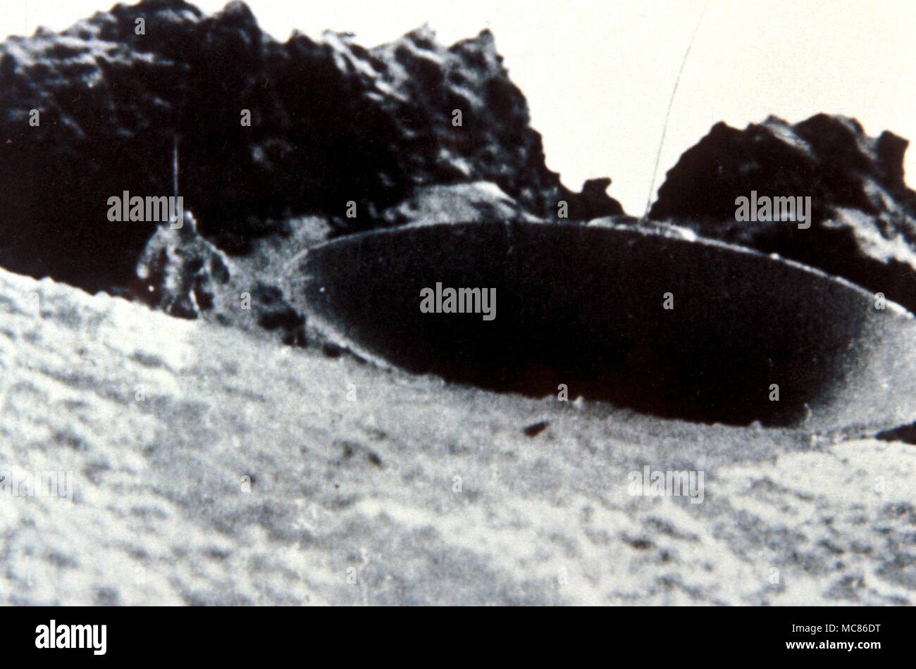 UFO - unidentified flying object Photograph of landed ufo (with alien visible to the left of the craft) taken by Gampiere Montguzzi on the Bernina Glacier, Italy. One of a series Stock Photo