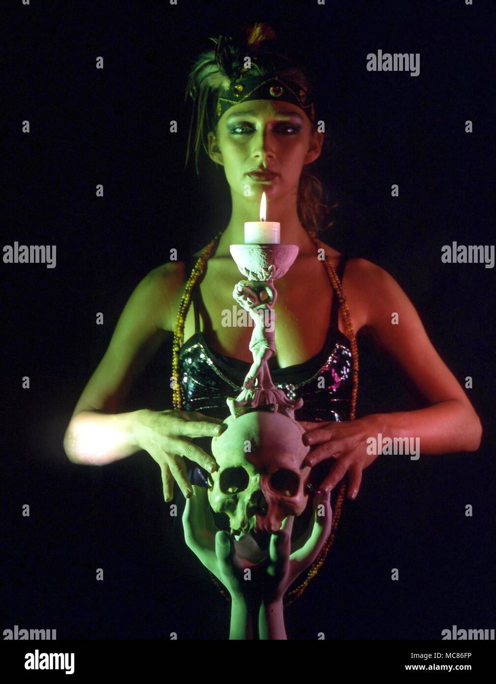 Girl practising candle magic, with candle in exotic holder Stock Photo