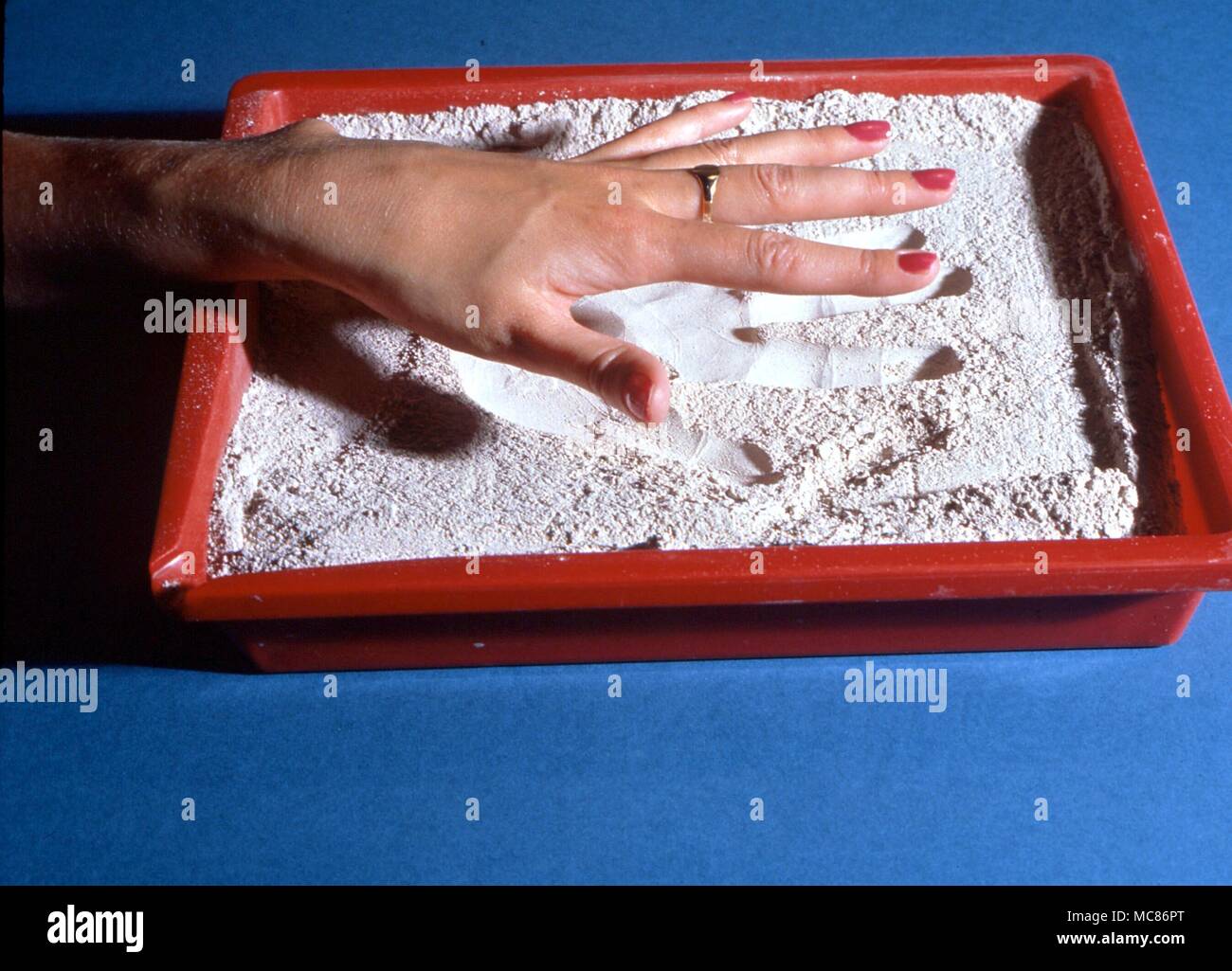 Psychic Phenomena 'Psychometry', Sand-reading by psychometric means, of an impression left in sand by someone's hand. According to the theory of psychometry, every time a person touches an object, he or she leaves an impression of the aura on that object Stock Photo