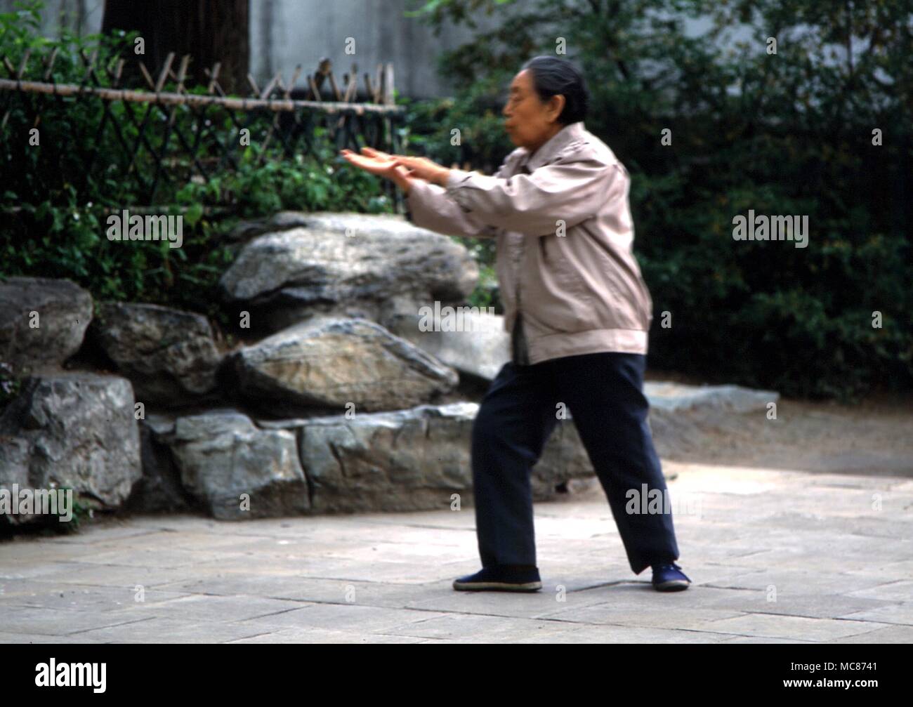 TAI CHI - Chinese lady practising Tai Chi in the gardens of a Beijing park, China Stock Photo
