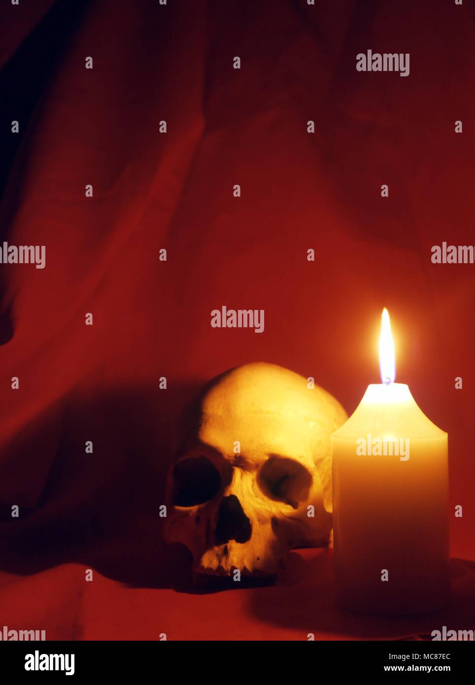 Large consecrated candle burning alongside a human skull. 2004 Charles Walker / Stock Photo
