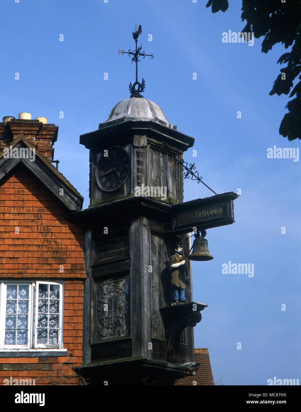 Horlogia and Clocks The Abinger Hammer clock sports a blacksmith who strikes the hours of a bell. The insciption reads By me you know how fast I go the hammer points to the fact that the village was an important forging district Stock Photo
