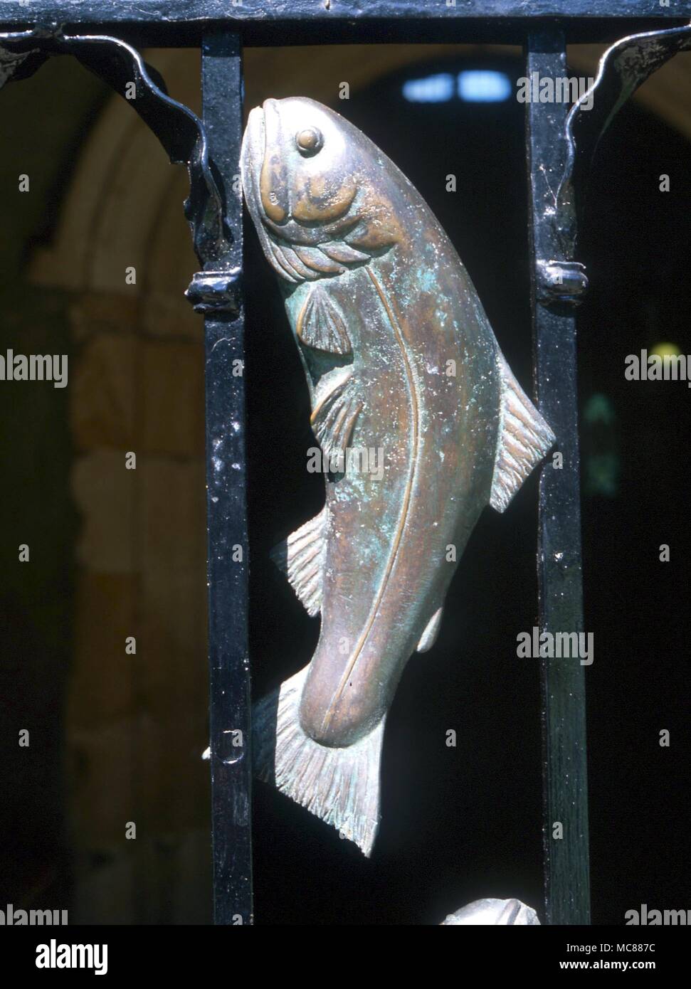 CHRISTIAN Fish from among a group of eight which decorate the metal porch gate of the church of St Michael. The fish is a symbol for Christ Stock Photo
