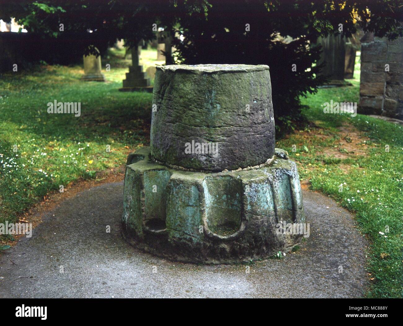 CHRISTIAN The Medieval kneeling cross (of which only the base remains) in Ripley churchyard Stock Photo