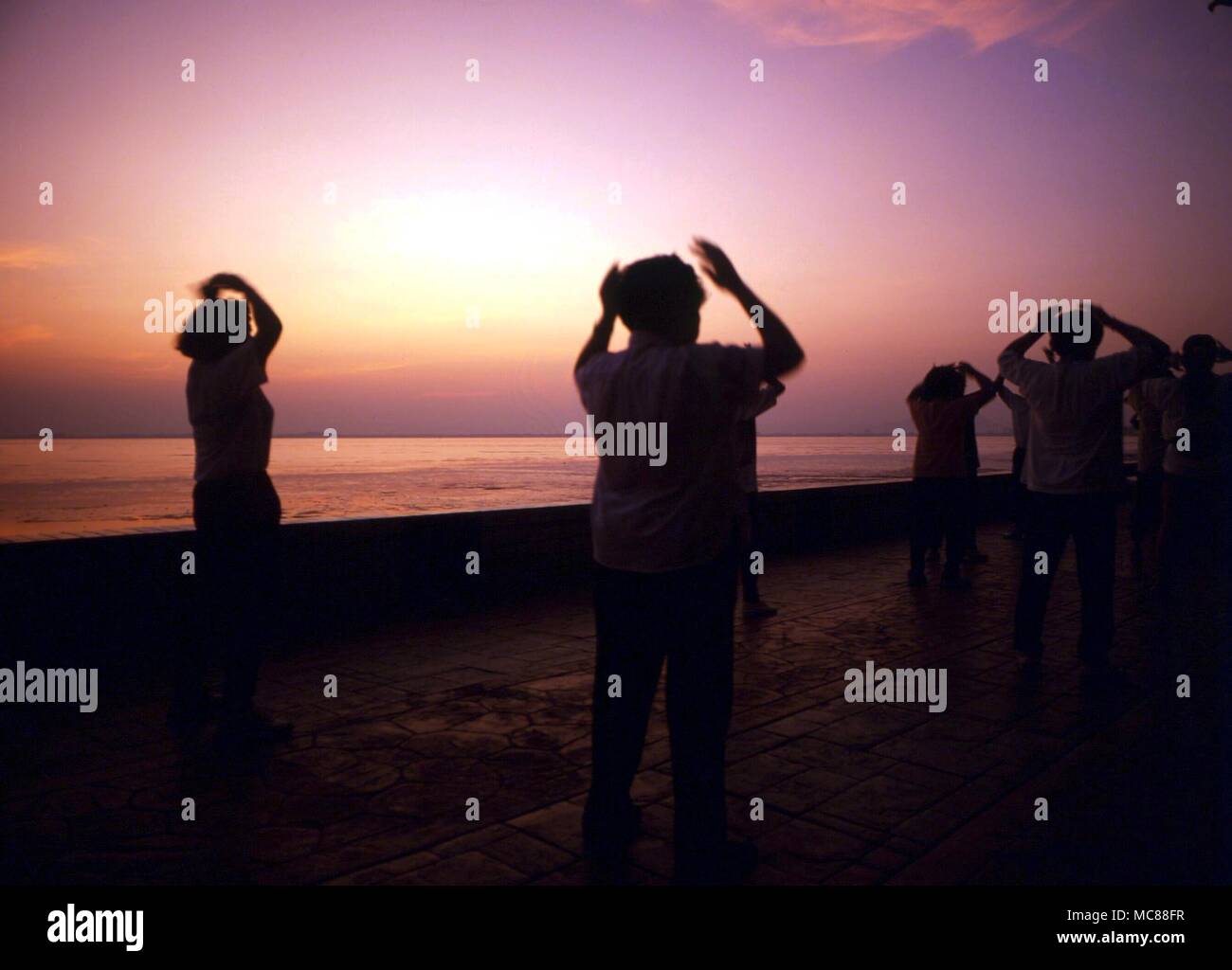 TAI CHI - Chinese practising Tai Chi at sunrise on the coast of Malaysia Stock Photo