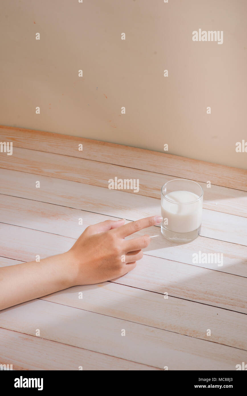 Male hand touching a glass of organic milk Stock Photo