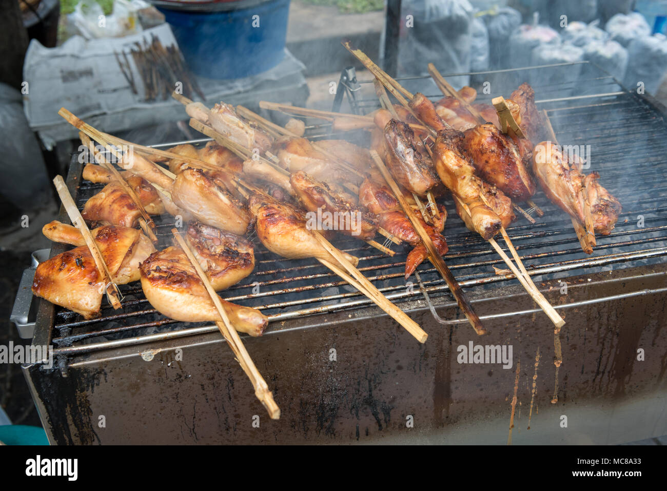 Chicken wing street food cooking on a charcoal grill in Bangkok Thailand Stock Photo