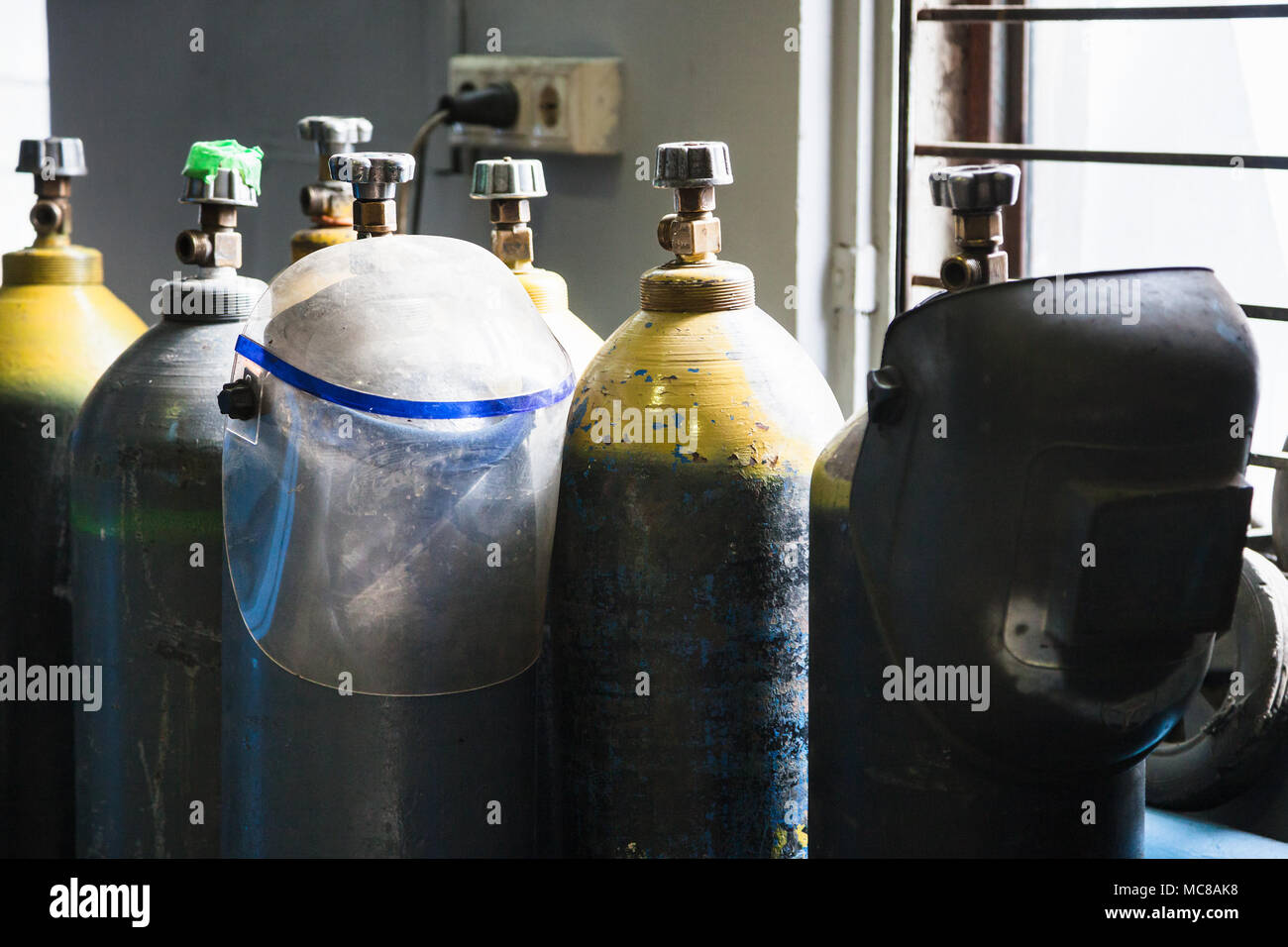 gas cylinders and welder protection masks in workshop Stock Photo