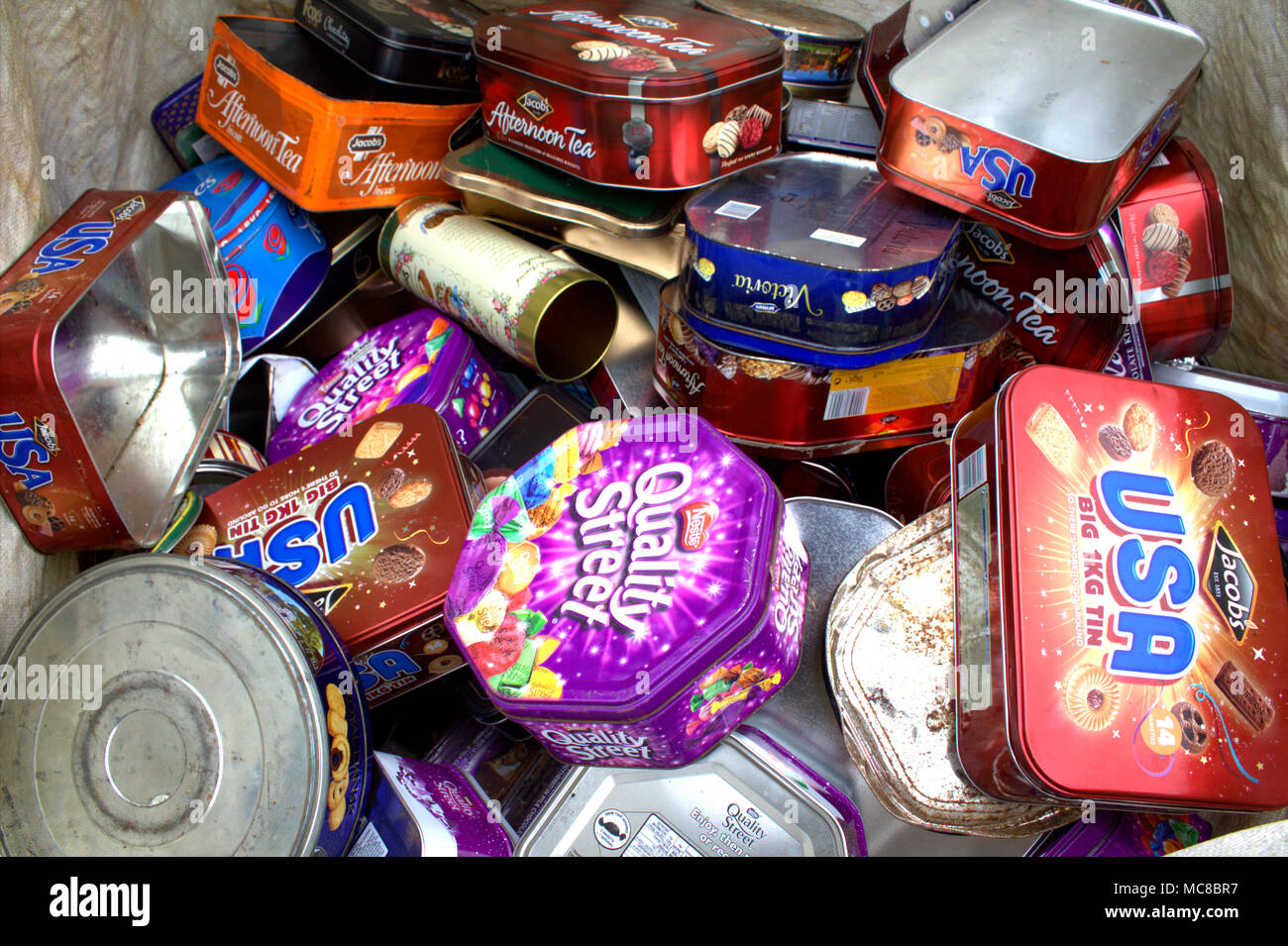empty biscuit tins collected and bagged up ready to be recycled in a metal recycling plant Stock