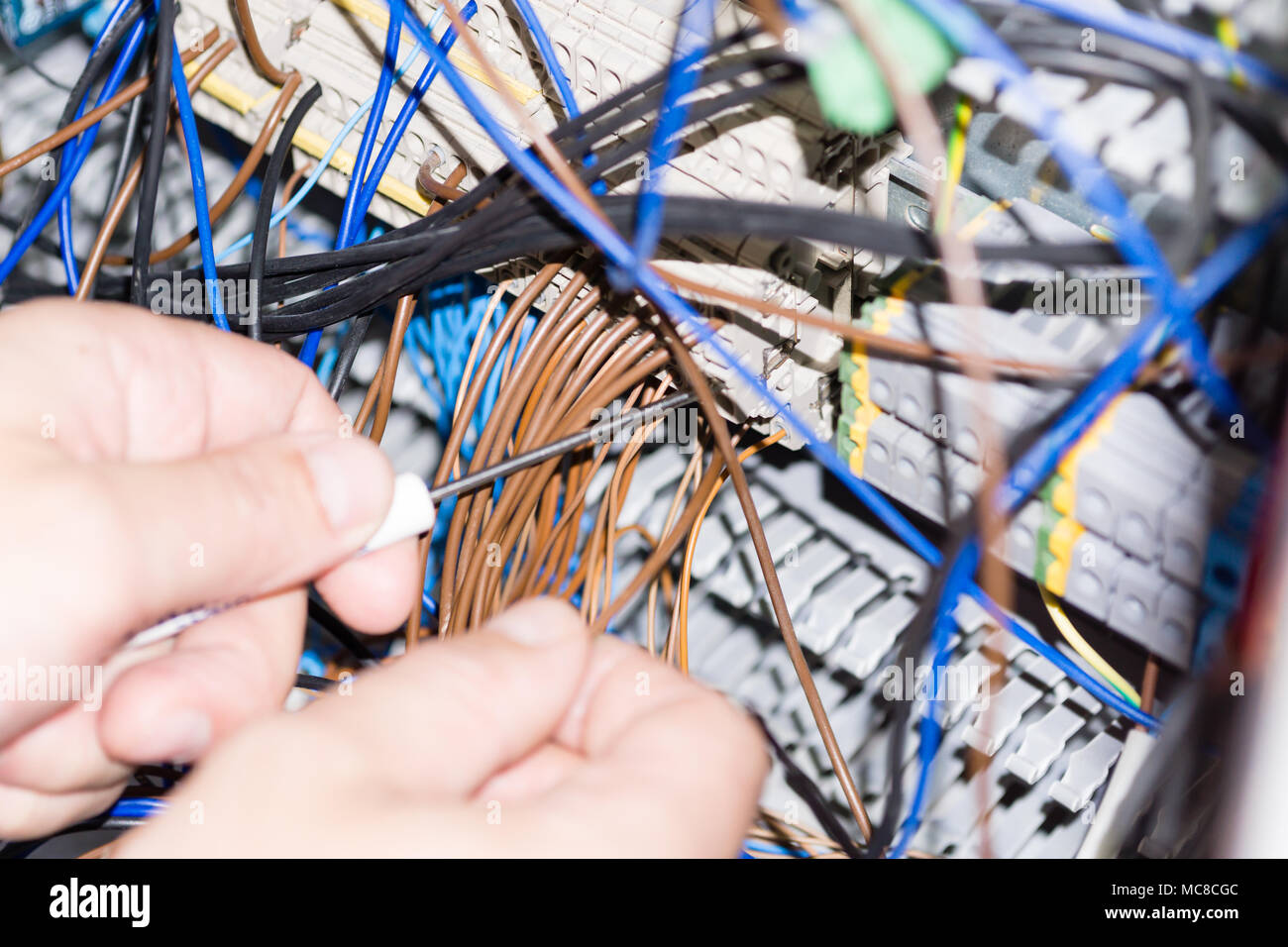 engineer hands installing electrical components in fuse box. Industry 4. Measuring voltage Stock Photo