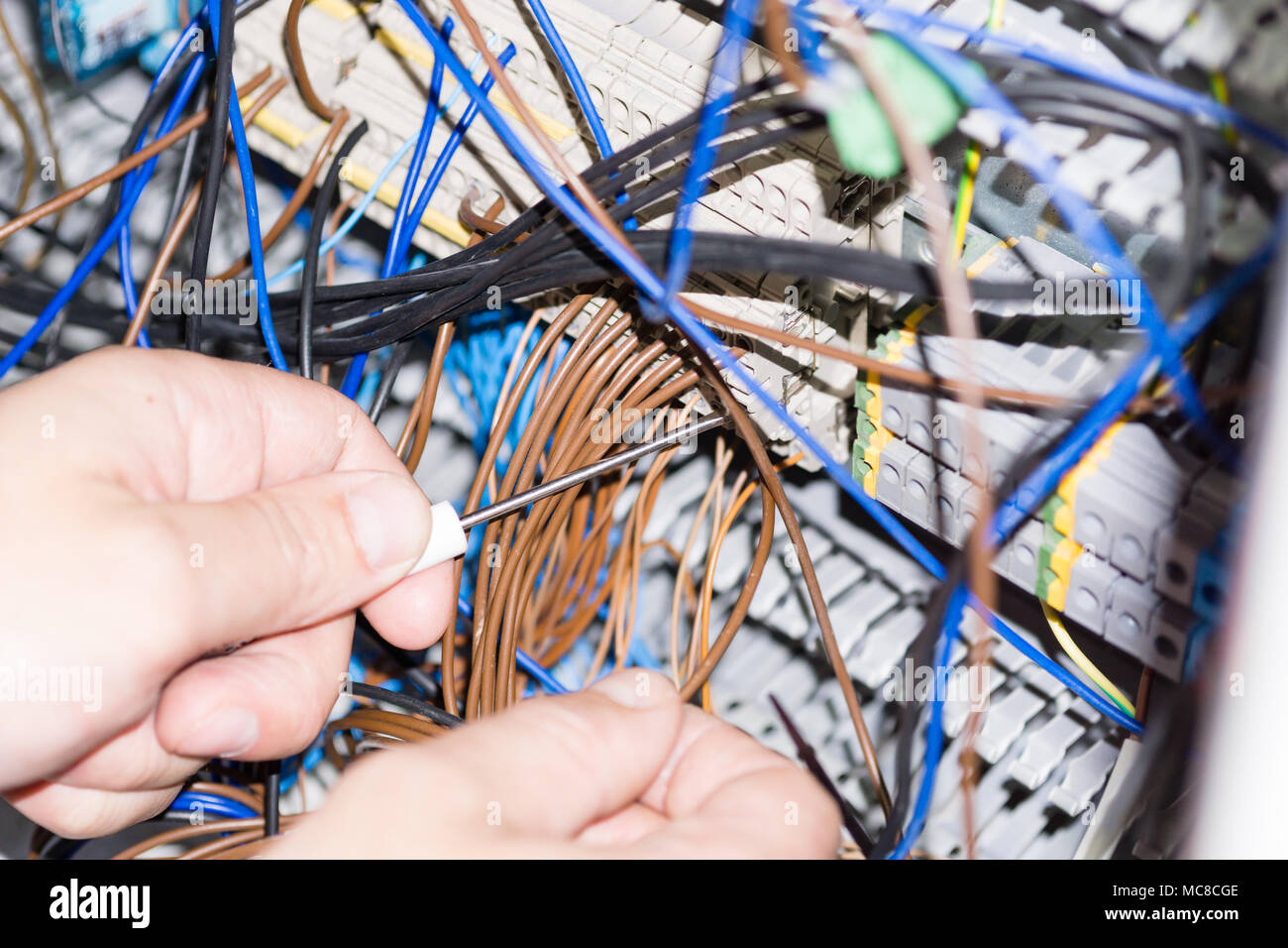 engineer hands installing electrical components in fuse box. Industry 4. Measuring voltage Stock Photo