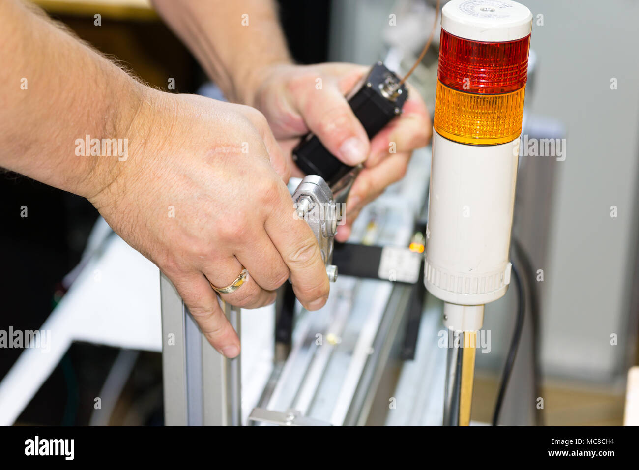 Engineer hands installing robotic machine vision system in factory