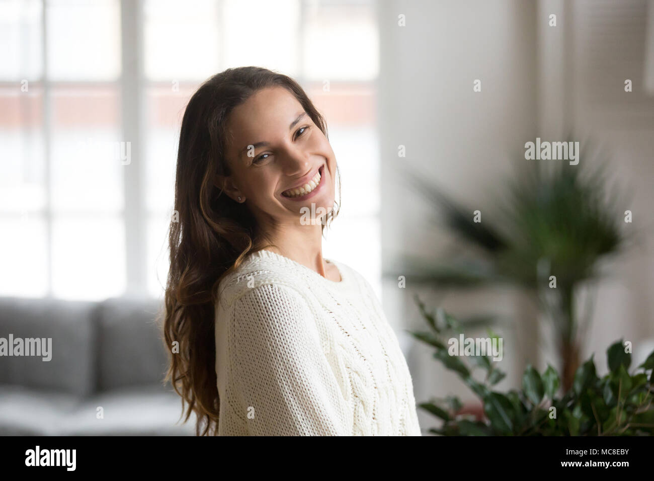 Cheerful happy mestizo girl with beautiful smile looking at camera, happy friendly young woman feeling glad and positive posing indoor at home, teenag Stock Photo