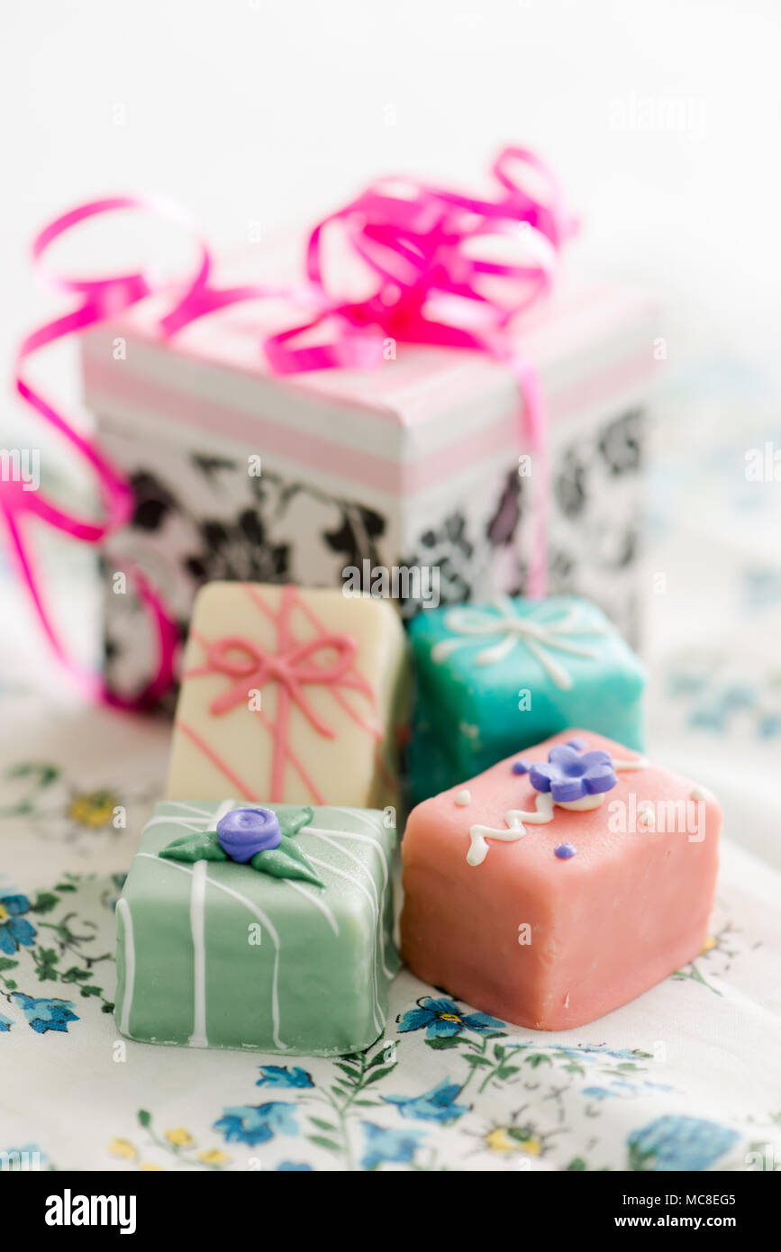 Petit fours in pastel colors with a gift box Stock Photo