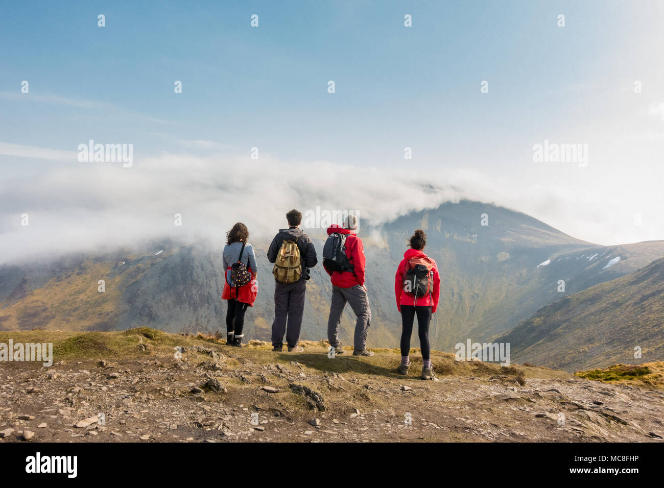 Lake District scene walkers standing on Ullock Pike looking over the