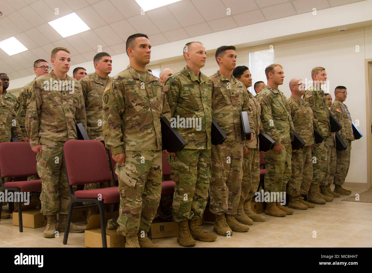 US Army Soldiers from the 319th Expeditionary Signal Battalion, 505th Signal Brigade, 335th Signal Command [Theater], stand at attention after receiving awards for a job well done while overseas at North Fort Hood, Texas, on March 24, 2018. This reserve battalion walked away from their civilian lives to enhance and train American Allies in cutting edge cyber security and warfare techniques all across the Horn of Africa, strengthening communications between the US and its African Allies. Stock Photo