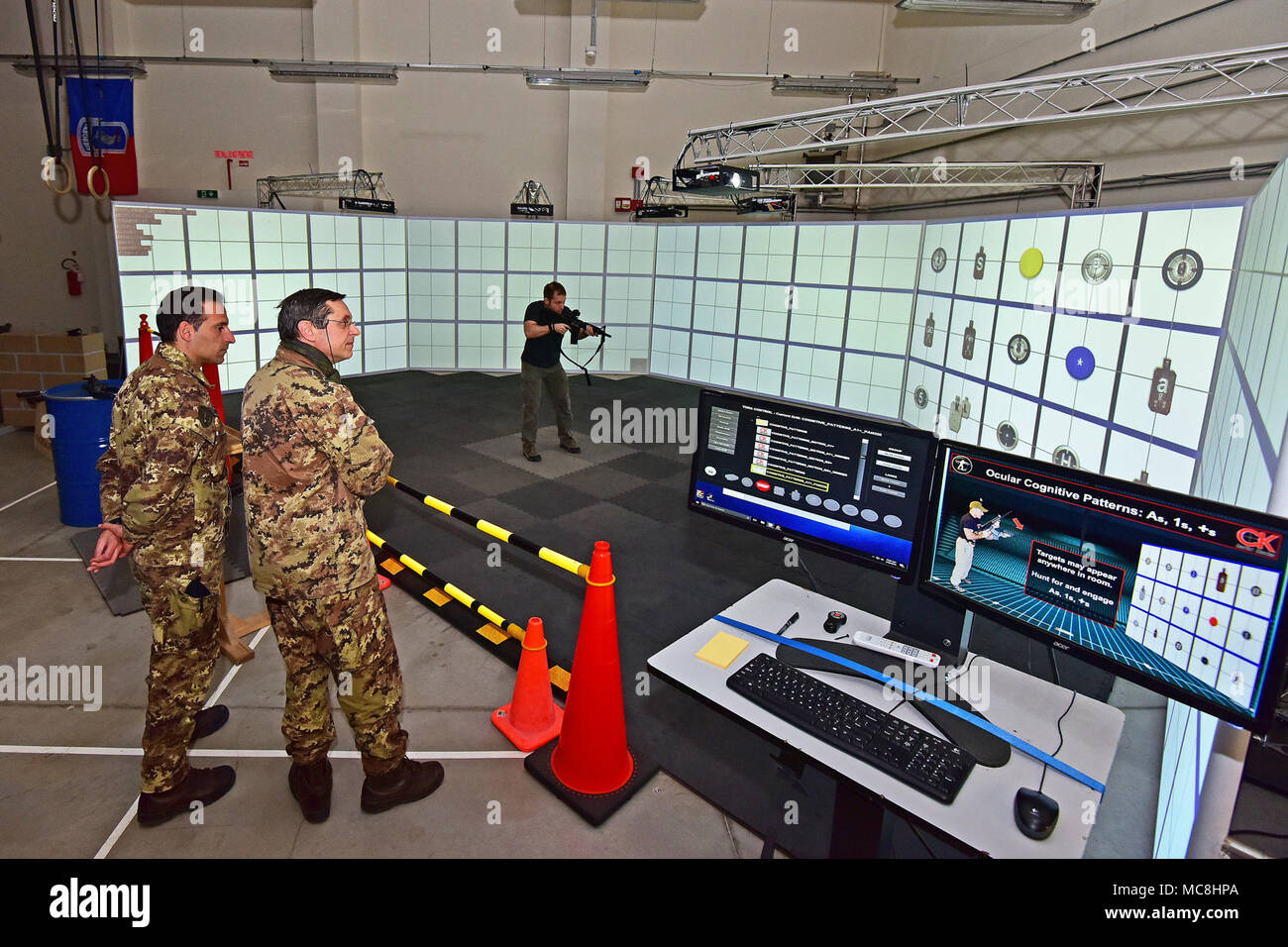 Michael Kennicker, instructor Gunfighter Gym (right), shows at Lt. Col. Giuseppe Galloro Chief Training Office of the 85th Reggimento Addestramento Volontari “Verona” (center) and Caporale Maggiore Capo Scelto Damiano (left) , simulated shooting drill at the Gunfighter Gym , Caserma Del Din, Vicenza, Italy, March 28, 2018. Italian Soldiers use U.S. Army RTSD South equipment to enhance bilateral relations and to expand levels of cooperation and the capacity of the personnel involved in joint operations. Stock Photo