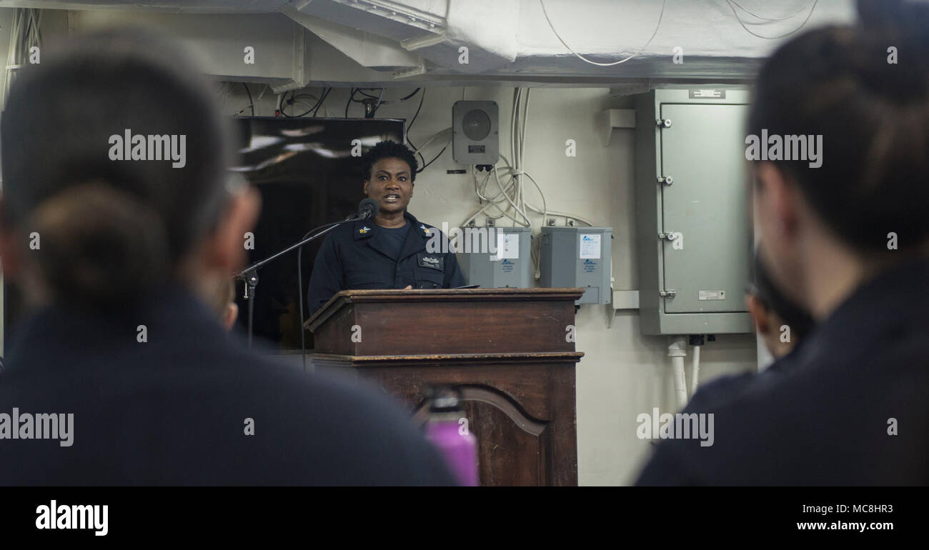 5TH FLEET AREA OF OPERATIONS (March 28, 2018) Logistics Specialist 1st Class Toni Acid gives a speech during a Women's History Month celebration on the mess decks of the Wasp-class amphibious assault ship USS Iwo Jima (LHD 7), March 28, 2018. Iwo Jima, homeported in Mayport, Florida, is on a regularly scheduled deployment to the U.S. 5th Fleet area of operations in support of maritime security operations to reassure allies and partners, and preserve the freedom of navigation and the free flow of commerce in the region. Stock Photo