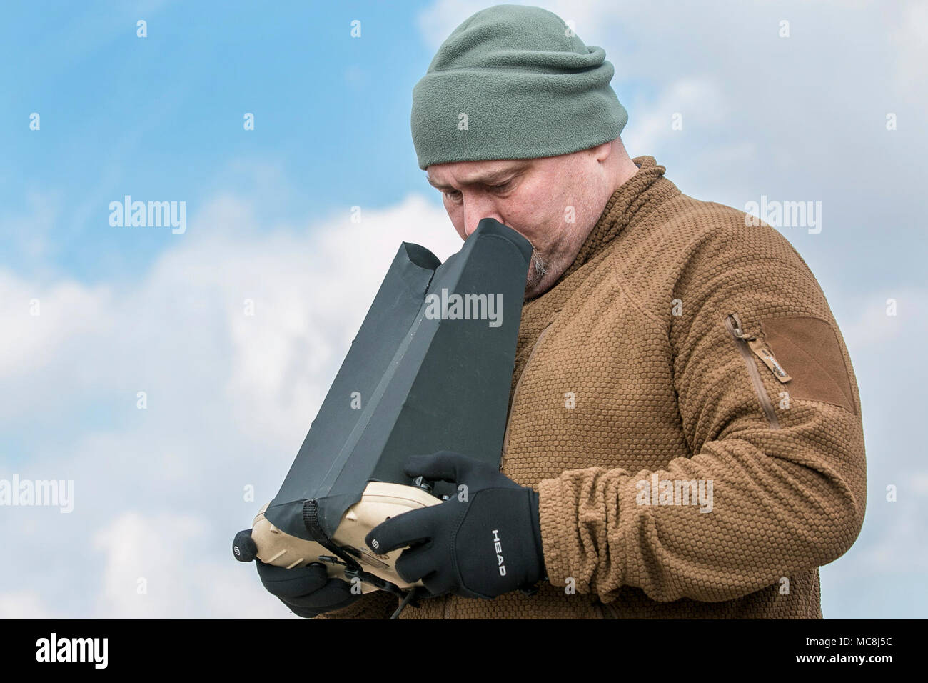 Michael Knox, a Puma operator, uses a remote control system to operate the aerial asset during a multinational joint equipment training brief April 2, 2018 in Grafenwoehr, Germany in preparation for a Robotic Complex Breach Concept demonstration. The Robotic Complex Breach Concept includes the employment of Robotic and Autonomous Systems (RAS) in intelligence, suppression, obscuration, and reduction. Stock Photo