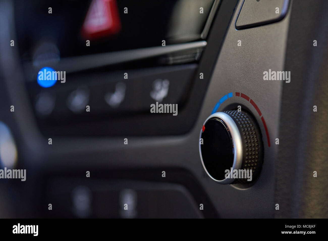 Car climate control knob close-up on blurred dashboard background Stock Photo