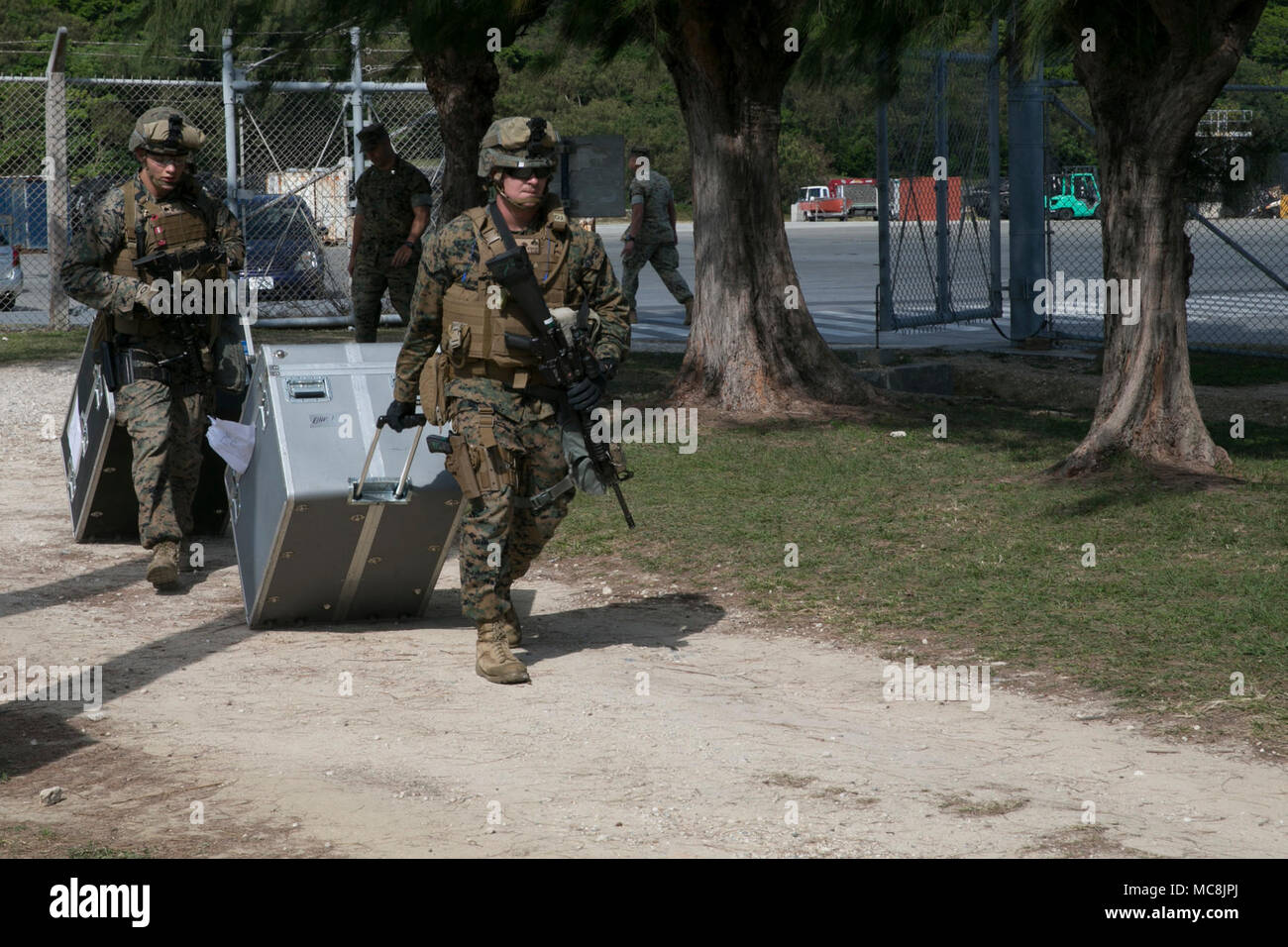 Marines with Combat Logistics Battalion 31 carry gear for the Humanitarian Assistance Survey Team during Amphibious Integration Training at White Beach Naval Facility, Okinawa, Japan, March 27, 2018. CLB-31 is the Logistics Combat Element for the 31st Marine Expeditionary Unit and provides combat support such as supplies, maintenance, and transportation. The HAST surveys areas that have been struck by natural disasters to determine how the 31st MEU can best lend its support. The 31st MEU and Amphibious Squadron 11 conduct AIT in preparation for Certification Exercise and to ensure readiness fo Stock Photo