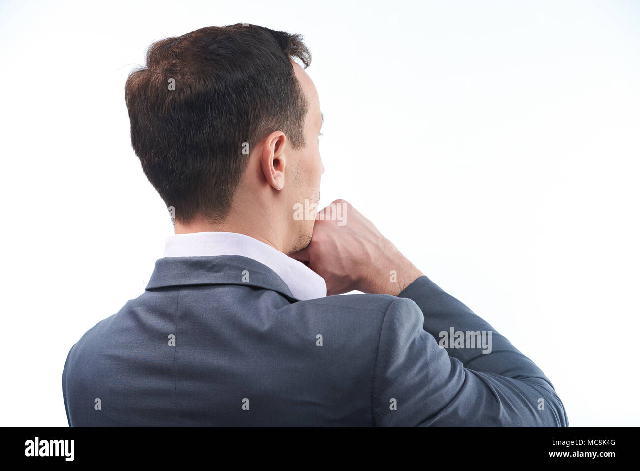 Back view of thinking man. Man with hand under chin Stock Photo