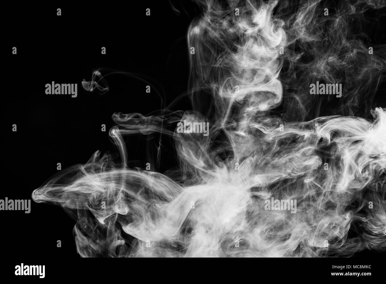 Thick white smoke on a black isolated background. Background from the smoke of vape Stock Photo
