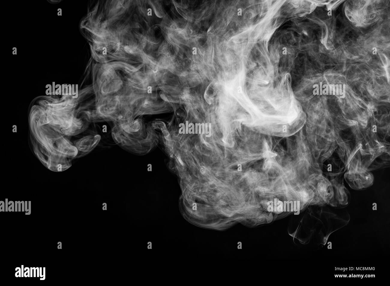 Thick white smoke on a black isolated background. Background from the smoke of vape Stock Photo