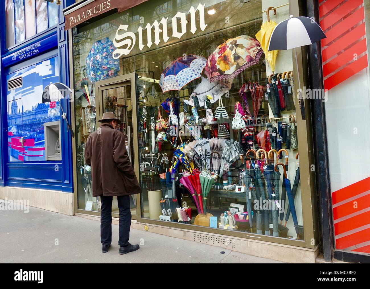 Older man, wearing rugged coat and hat, looking at umbrellas in a shop  window Blvd Saint-Michel, Paris, France Stock Photo - Alamy