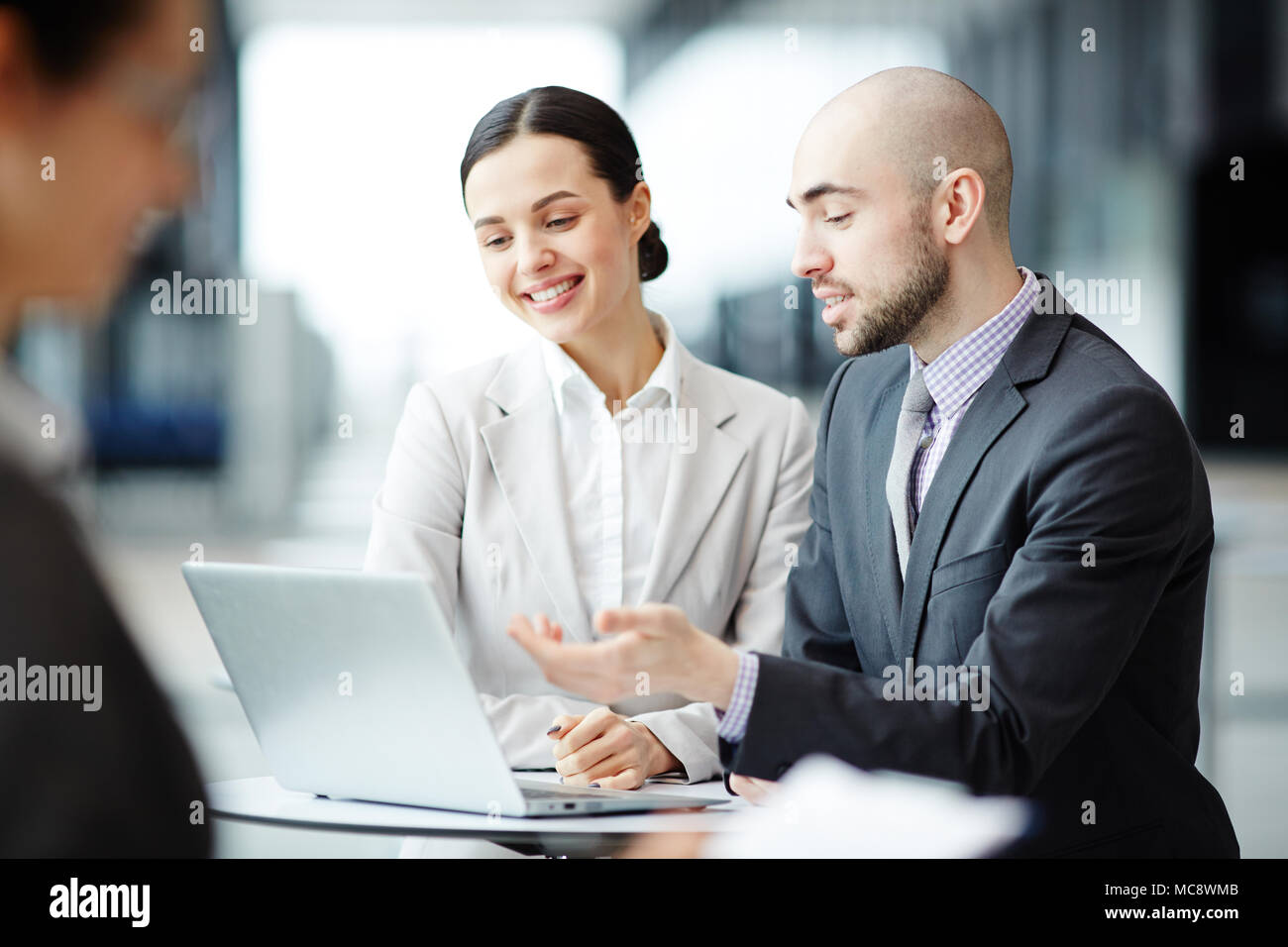 One of managers explaining his colleague online information while ...