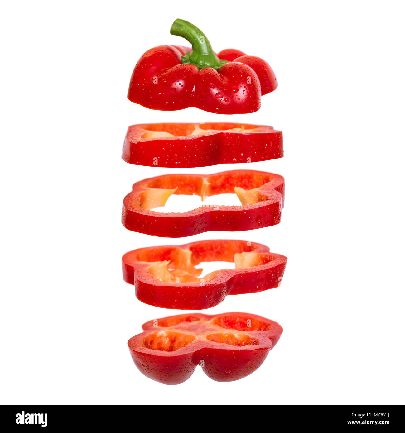 Creative concept with flying red paprika. Sliced floating pepper. Levity capsicum vegetable isolated on white background Stock Photo