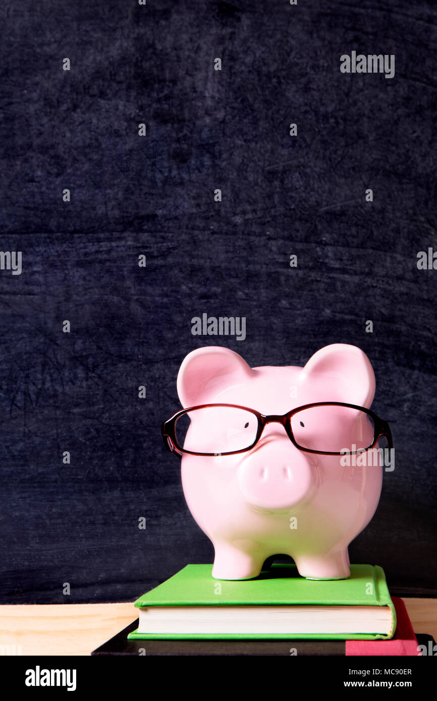 Piggy bank with glasses and blackboard Stock Photo - Alamy