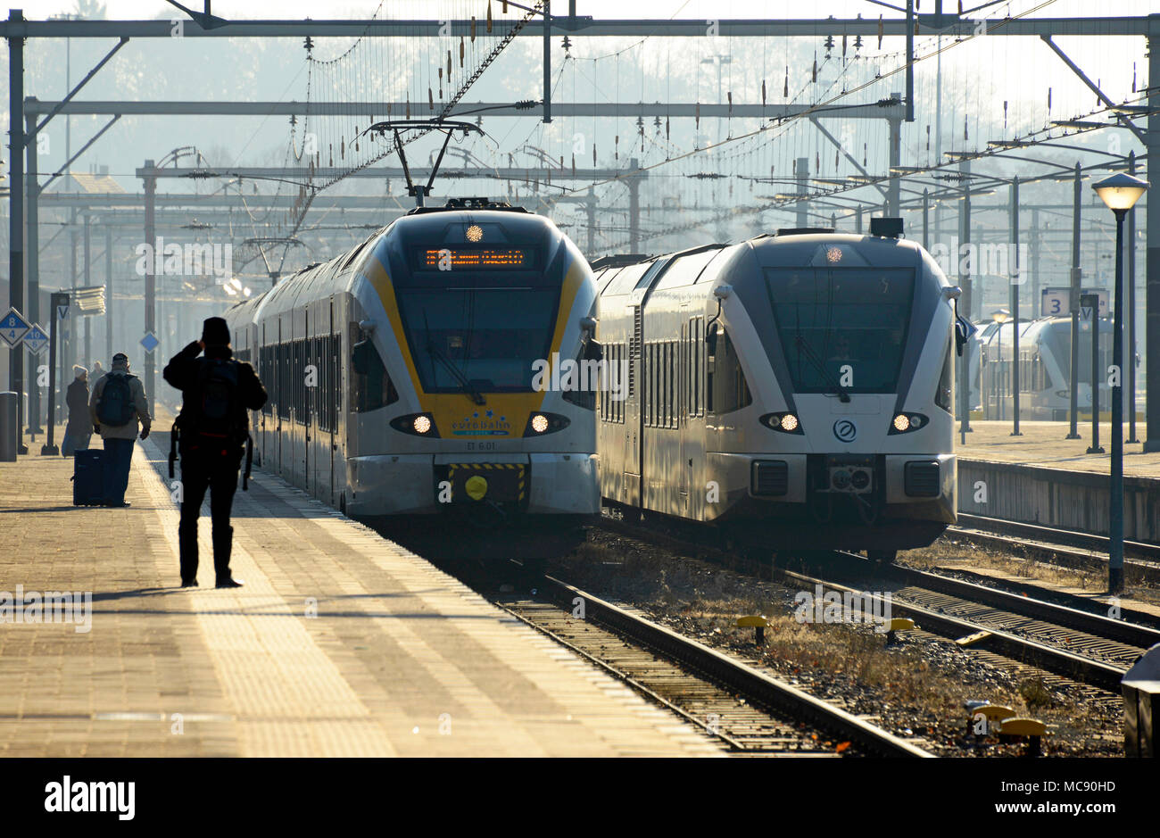 A train from Germany approaches Venlo in the Netherlands as another waits at the station platform to depart Stock Photo