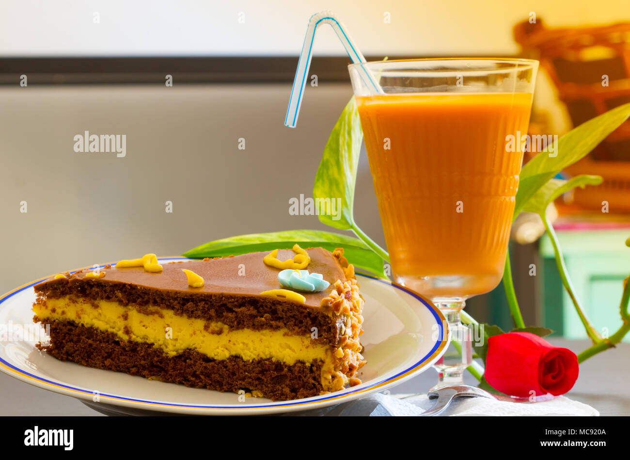 Delicious chocolate cake with iced tea glass or orange juice on table