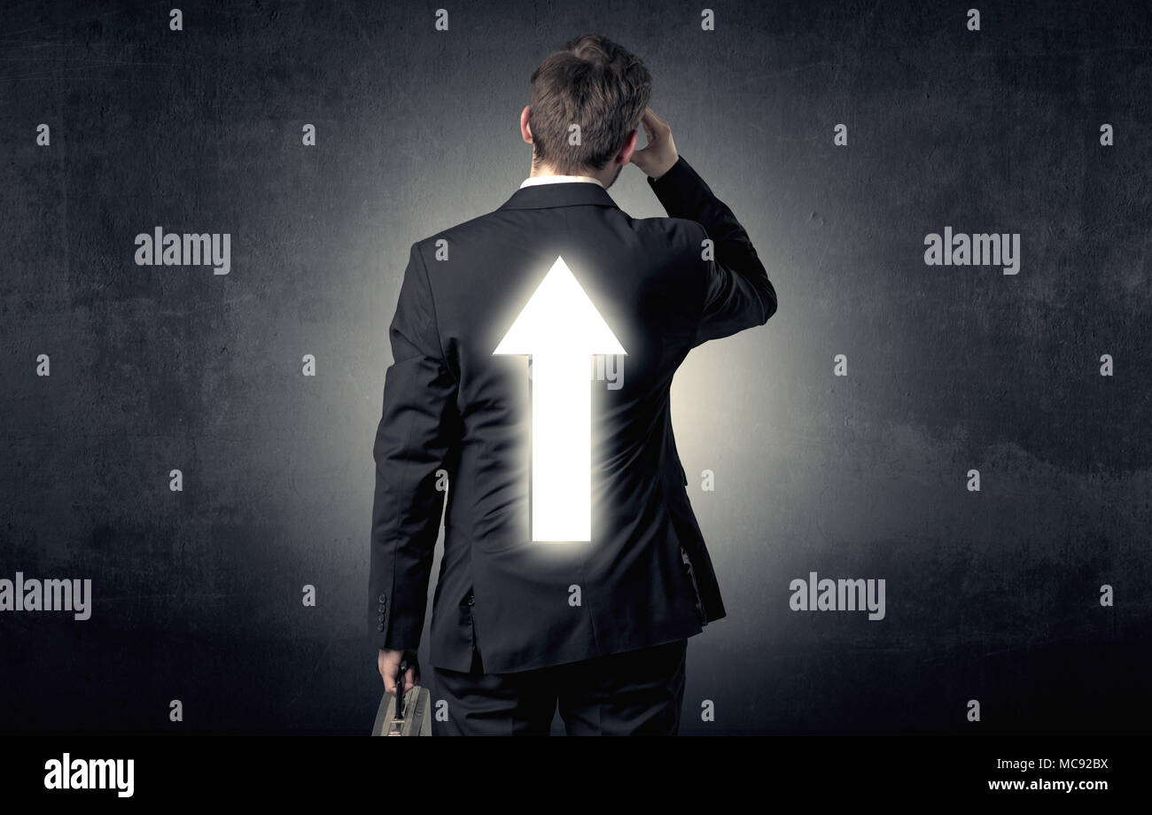 Young businessman standing and thinking about which direction to choose ...