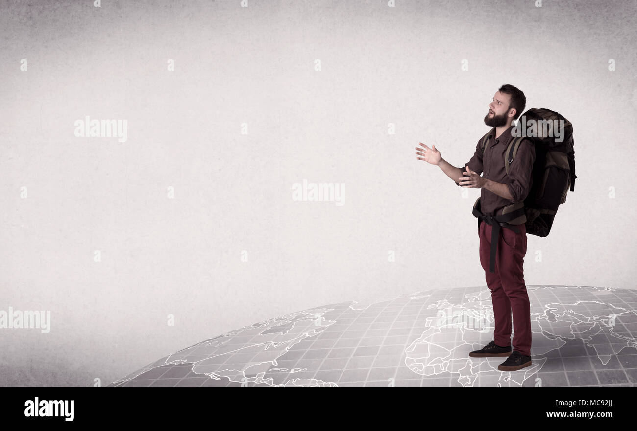 Handsome young man with a backpack on his back standing on a world map ...