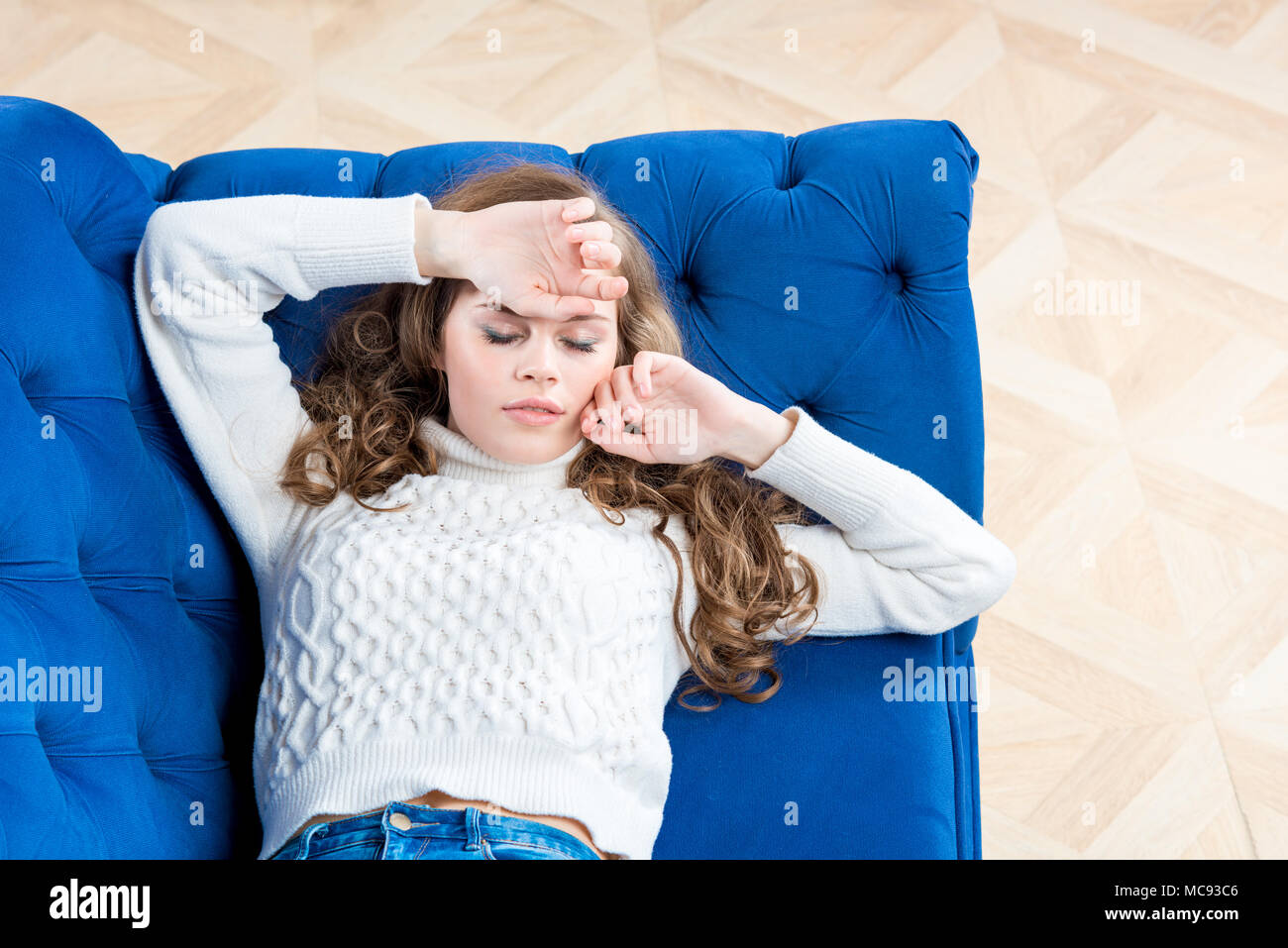 tired girl is sleeping on the couch in the living room in a sweater Stock  Photo - Alamy