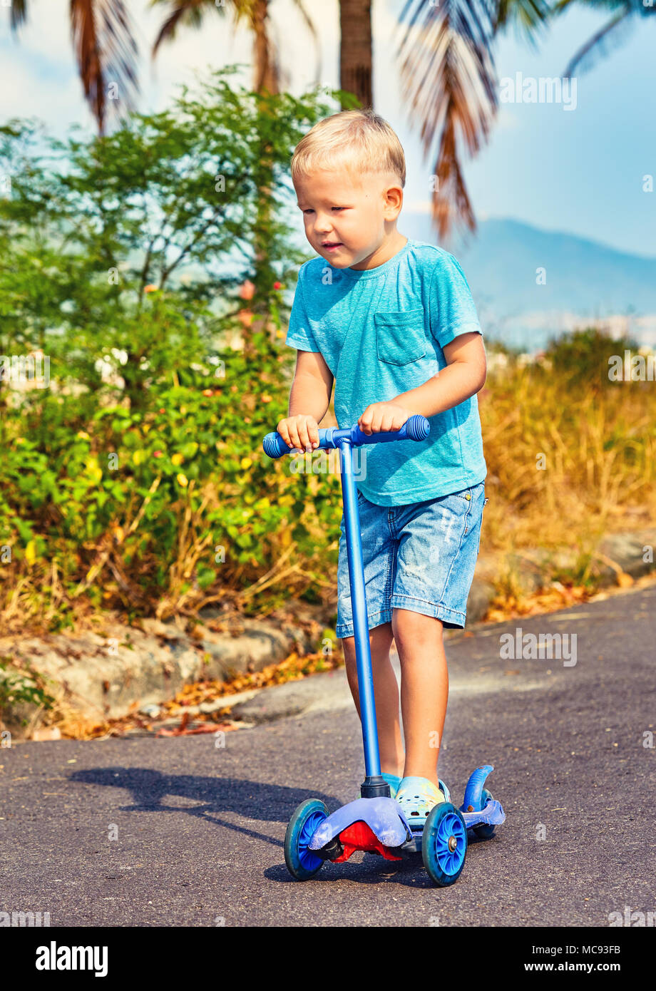 Cute boy riding kick scooter. Child outdoor activity Stock Photo Alamy