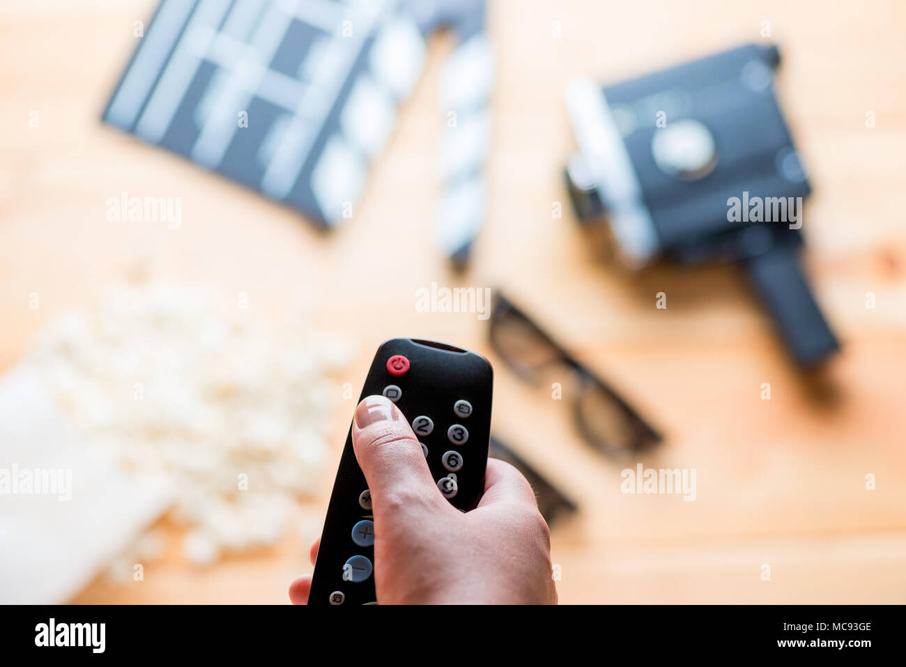 against the backdrop of the film industry objects close-up of TV remote in a female hand Stock Photo