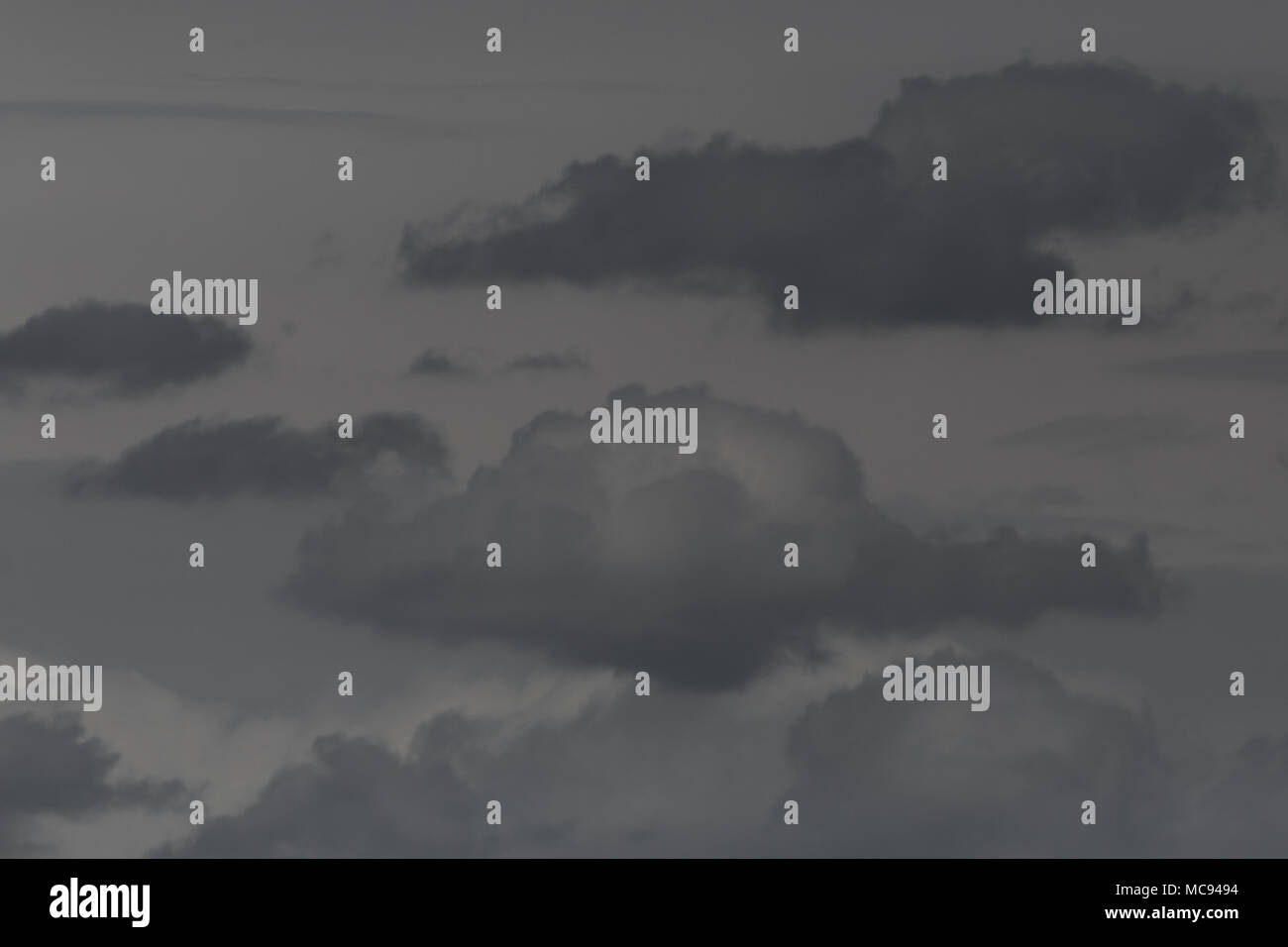 several isolated natural dark clouds in gray sky Stock Photo - Alamy
