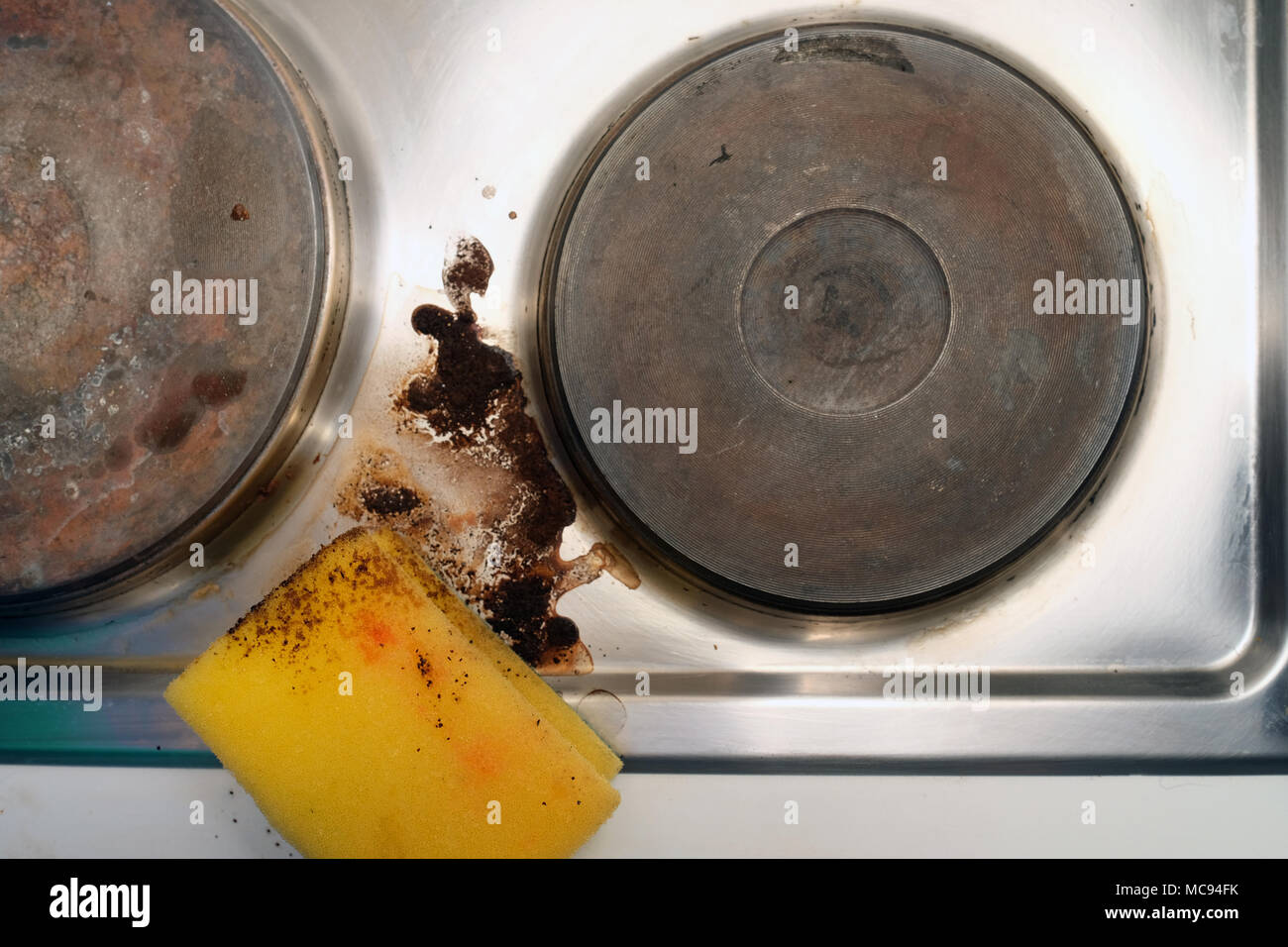 Sponge and stains from spilled coffeeremoving from a stove top Stock Photo