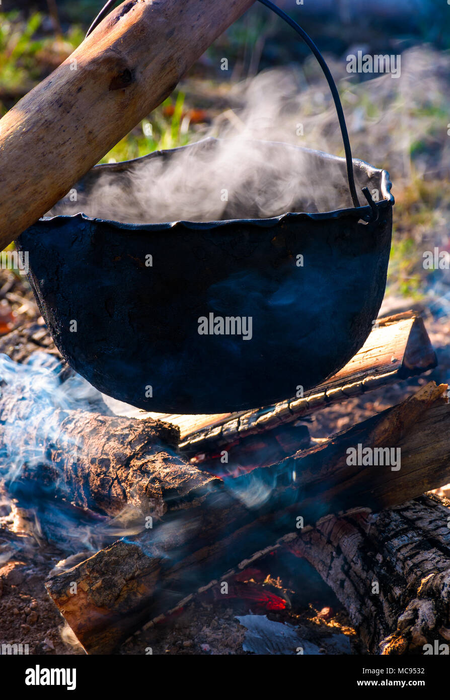 https://c8.alamy.com/comp/MC9532/cauldron-in-steam-and-smoke-on-open-fire-outdoor-cooking-concept-old-fashioned-way-to-make-food-MC9532.jpg