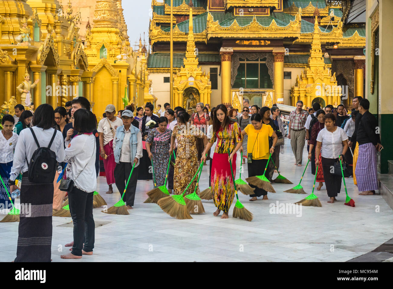 Sweepers sweep floor with brooms at Shwedagon Pagoda (temple) in Yangon, Myanmar, Asia Stock Photo