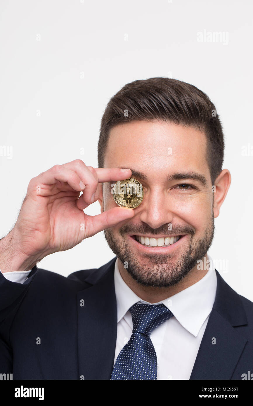 Professional businessman holding golden bitcoin in front of eye, isolated  on white Stock Photo - Alamy