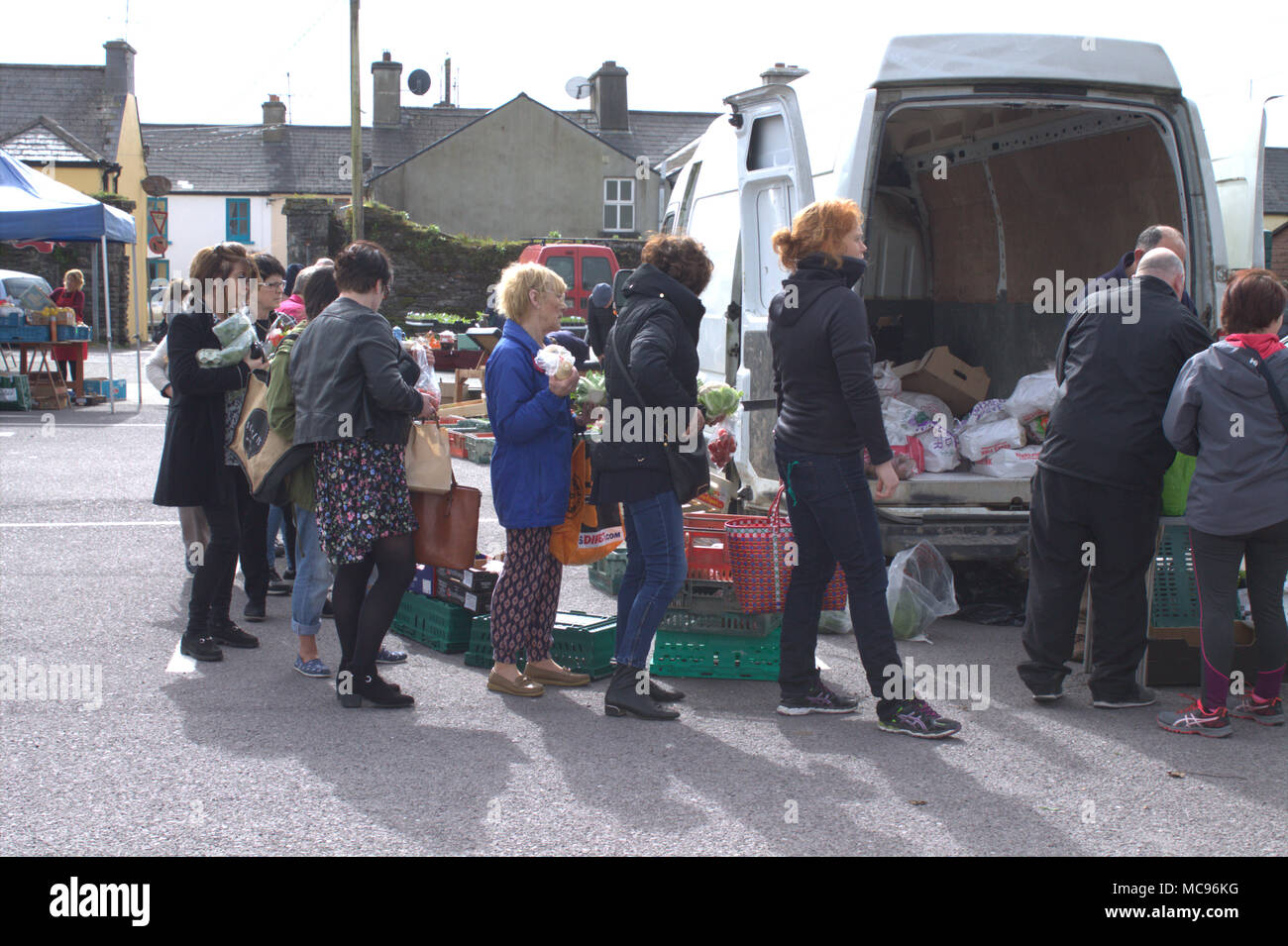 shoppers queue to pay for the fresh vegetables they are buying at a country food market. skibbereen, west cork, ireland a popular holiday town. Stock Photo